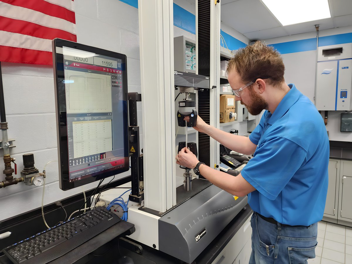 schneller-employee-focused-in-lab-performing-Instron-Tensile-&-Adhesive-Testing