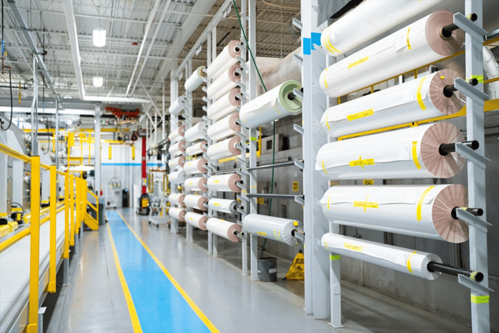 large-rolls-of-laminate-material-stack-along-wall-in-a-factory