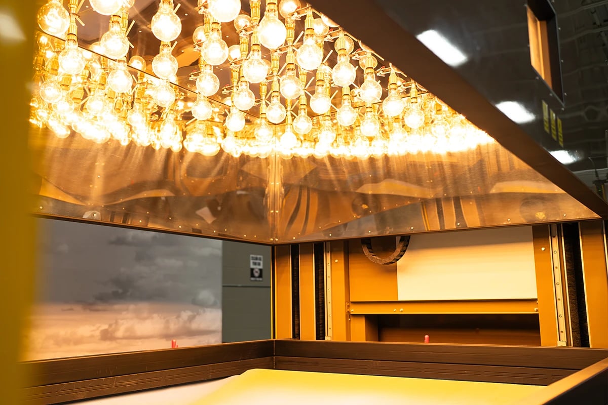 aircraft-environment-material-testing-machine-with-multiple-lightbulbs-suspended-above-a-flat-surface-where-aircraft-material-lays-to-be-tested-against-harsh-environmental-factors